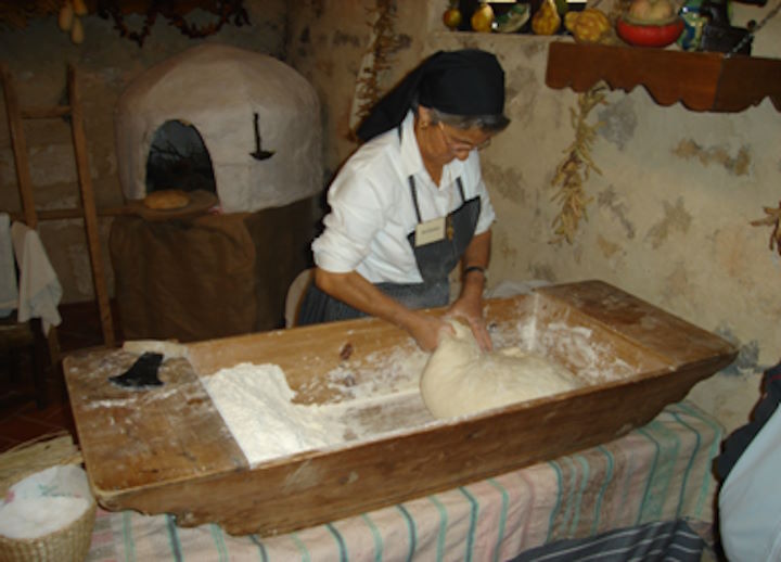 Mujer amasando en una artesa