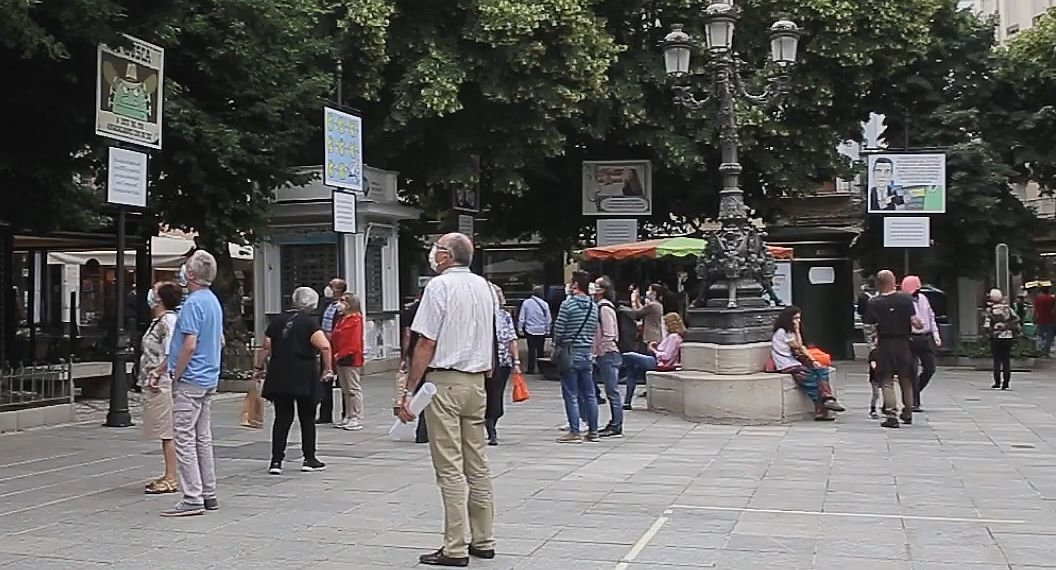 Granaínos leyendo las carocas del Corpus en la Plaza Bibrrambla