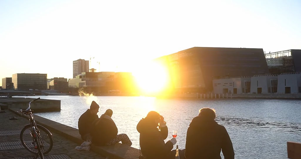 Tomando una copa de vino mientras el Sol se pone en el puerto de Copenhague