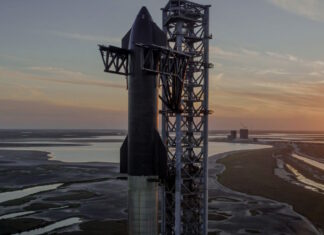 La nave Spaceship sobre un cohete Falcon Heavy en la torre de lanzamiento